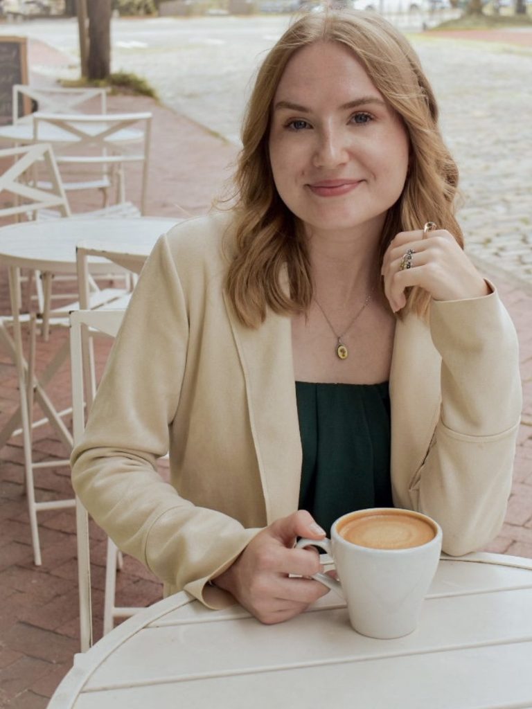 Capture & Close Real Estate Imagery Owner Man in a blue suit standing in front of a large abstract painting. Chad McPhatter
