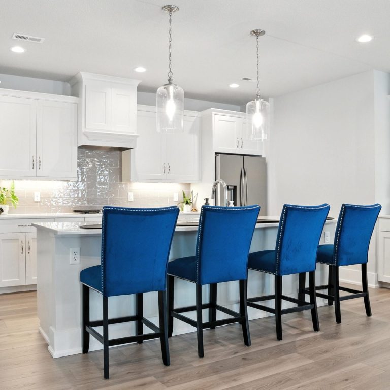 Modern Kitchen Modern kitchen with white cabinets and four blue bar stools at an island.
